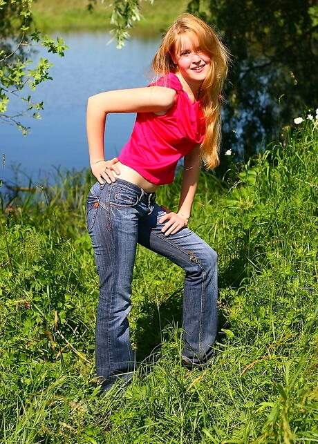 Sylphlike redheaded young Alina in jeans denudes tiny tits and shaved pussy outside